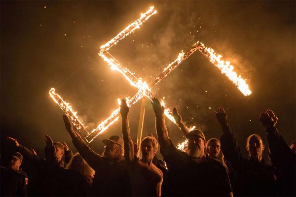 Members of the National Socialist Movement, one of the largest neo-Nazi groups in the US, hold a swastika burning on April 21, 2018, in Draketown, Georgia.